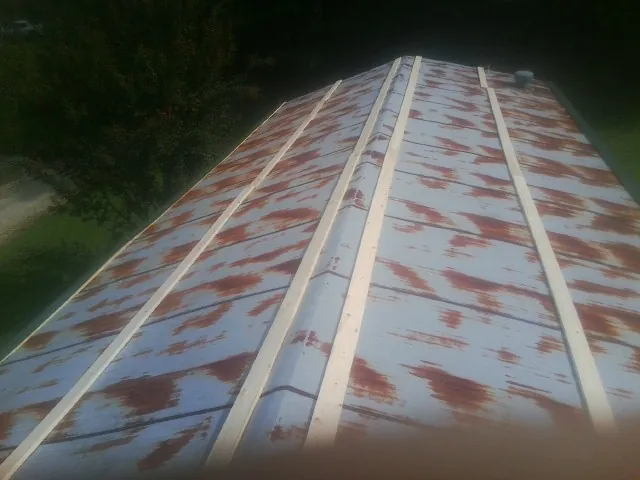 Rusted metal roof panels with new wood purlins before replacement — Storm Damage Roof Repair in Charles City by Roofing Brothers